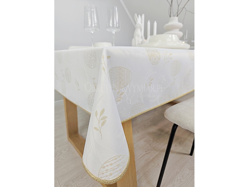 Detale wykończenia obrusu wielkanocnego złota lśniąca lamówka na białym materiale